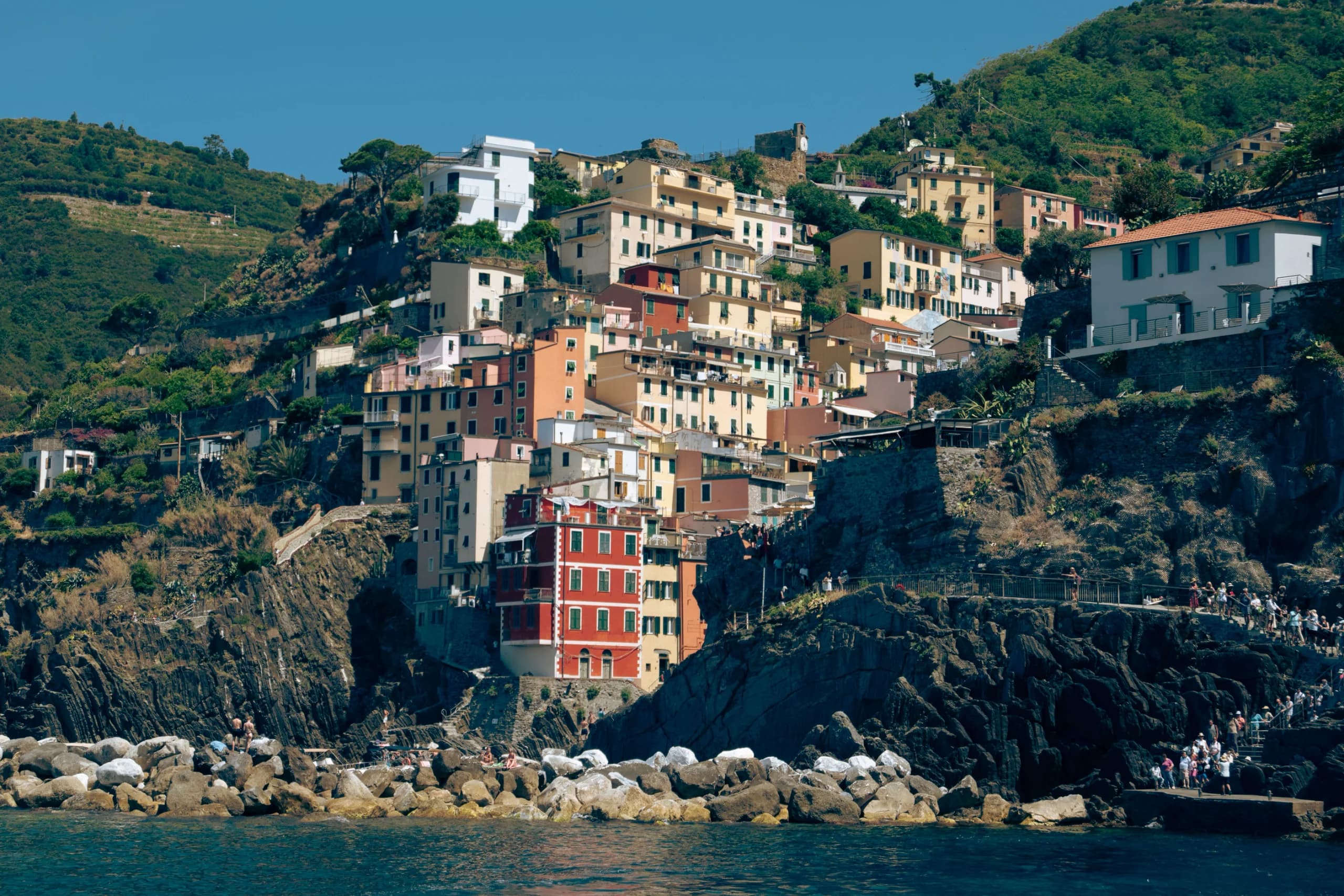 Colorful hillside view of the coastal village in Liguria, Italy, with vibrant buildings and rugged c