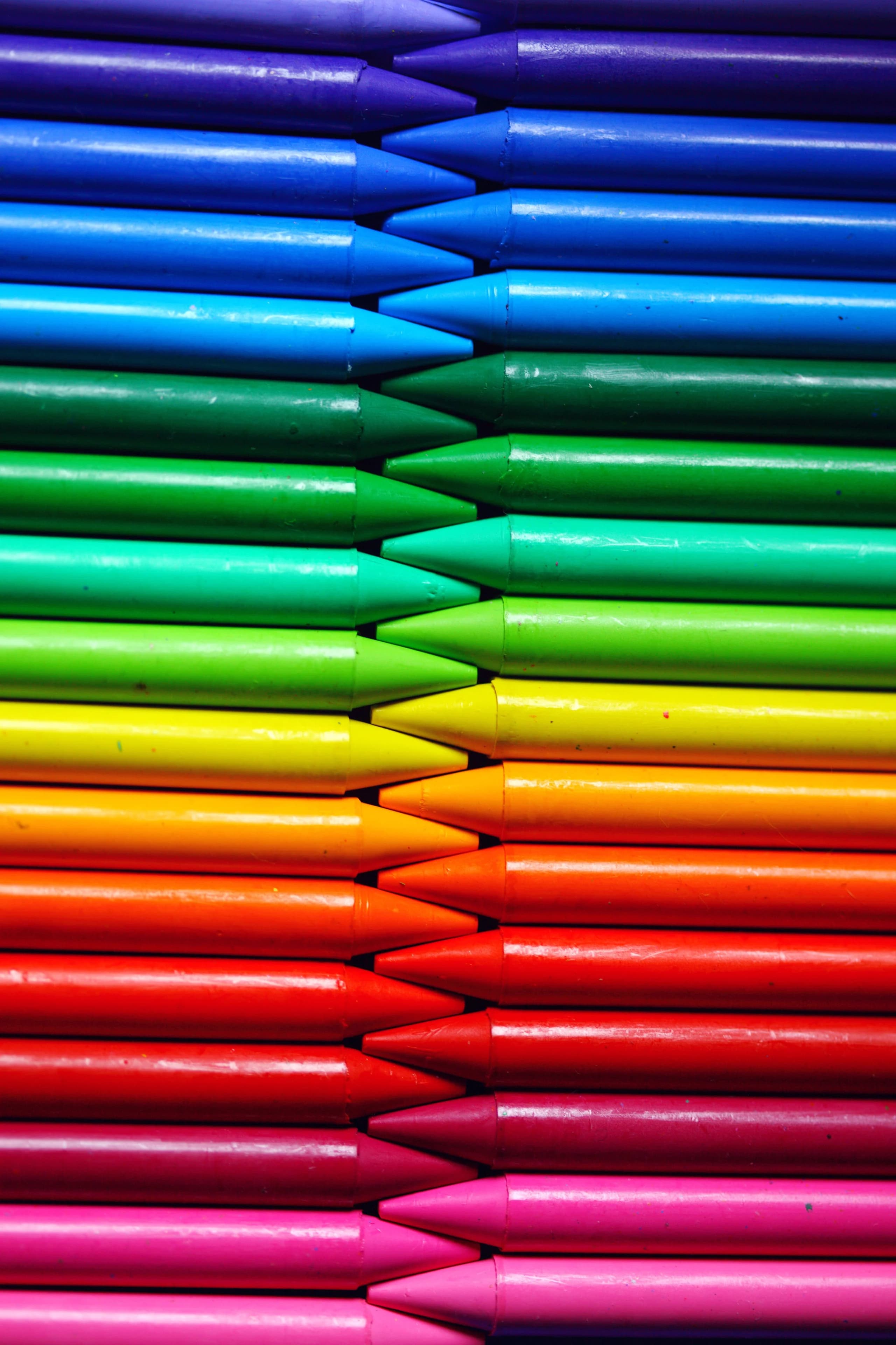 Colorful arrangement of crayons showcasing the spectrum of colors in a close-up vertical shot.