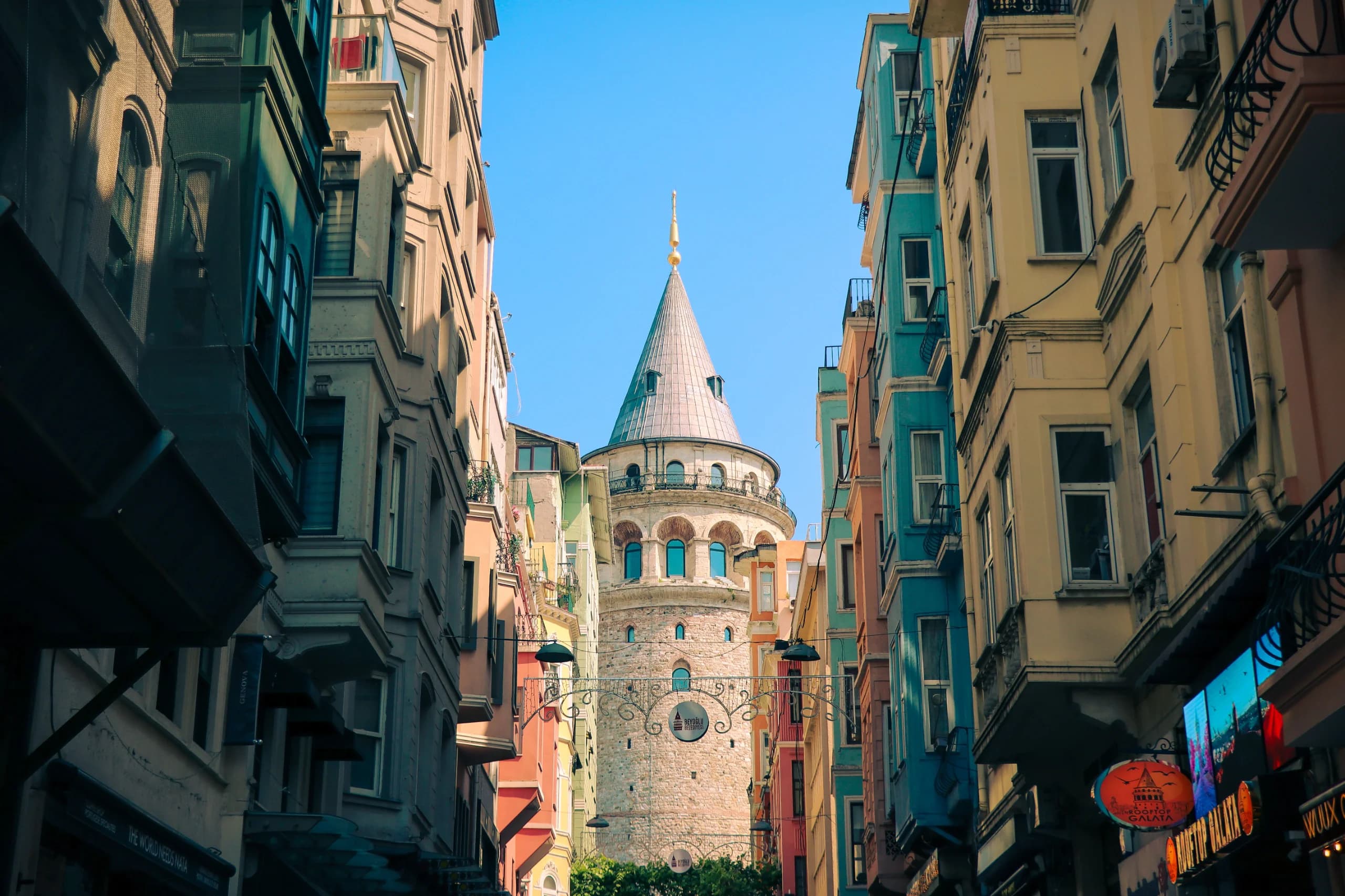 Stunning view of Istanbul's Galata Tower framed by colorful buildings, capturing urban charm.