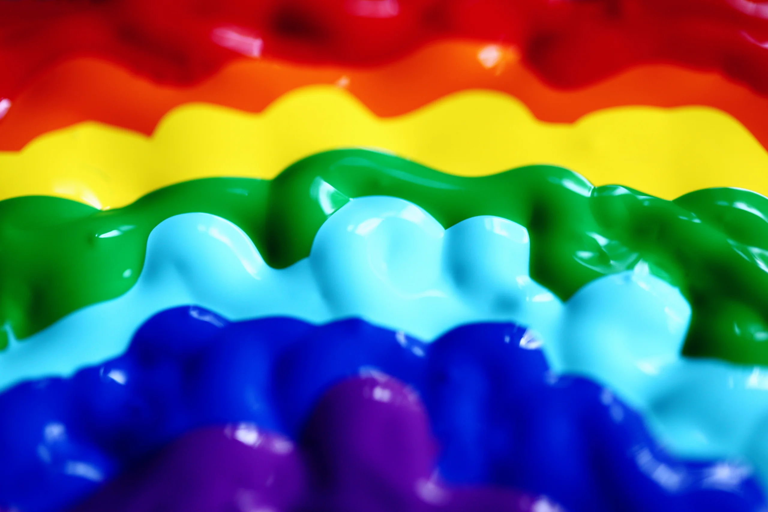 A close-up of colorful rainbow paint waves displaying vibrant hues in a creative pattern.