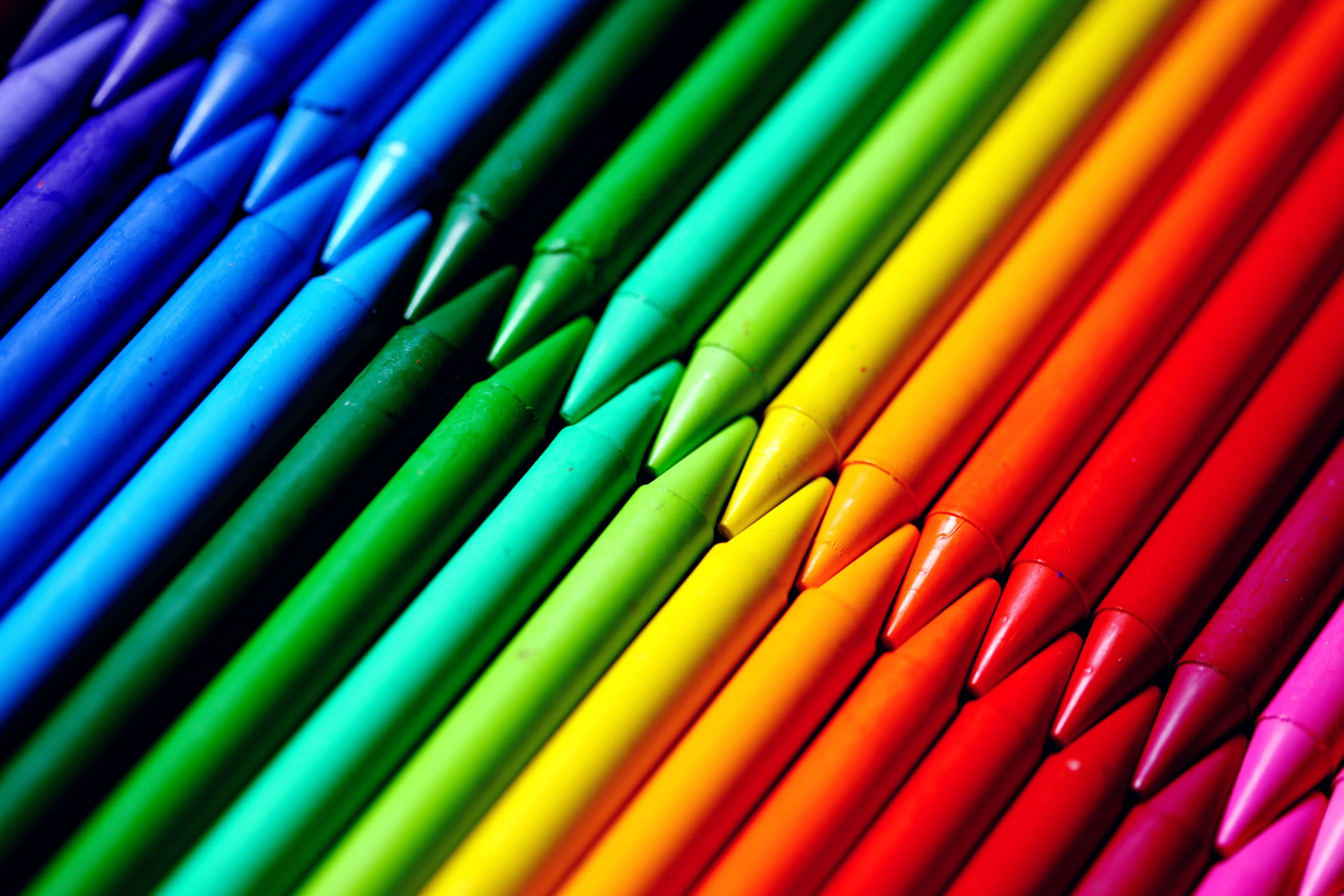 Flatlay of vivid colored crayons showcasing a spectrum of hues in a creative alignment.