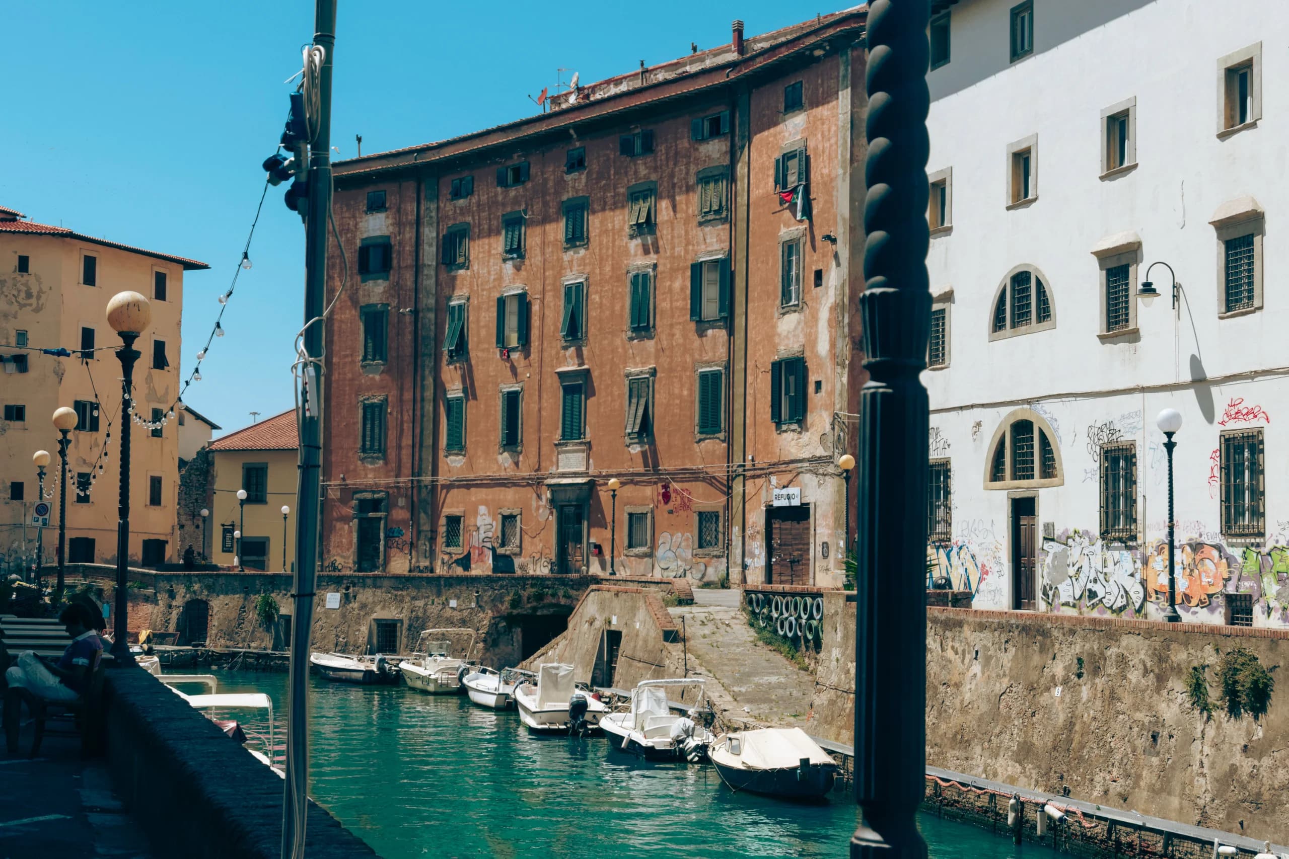 Explore the serene canals of Livorno, Tuscany, surrounded by historic buildings and a tranquil marin