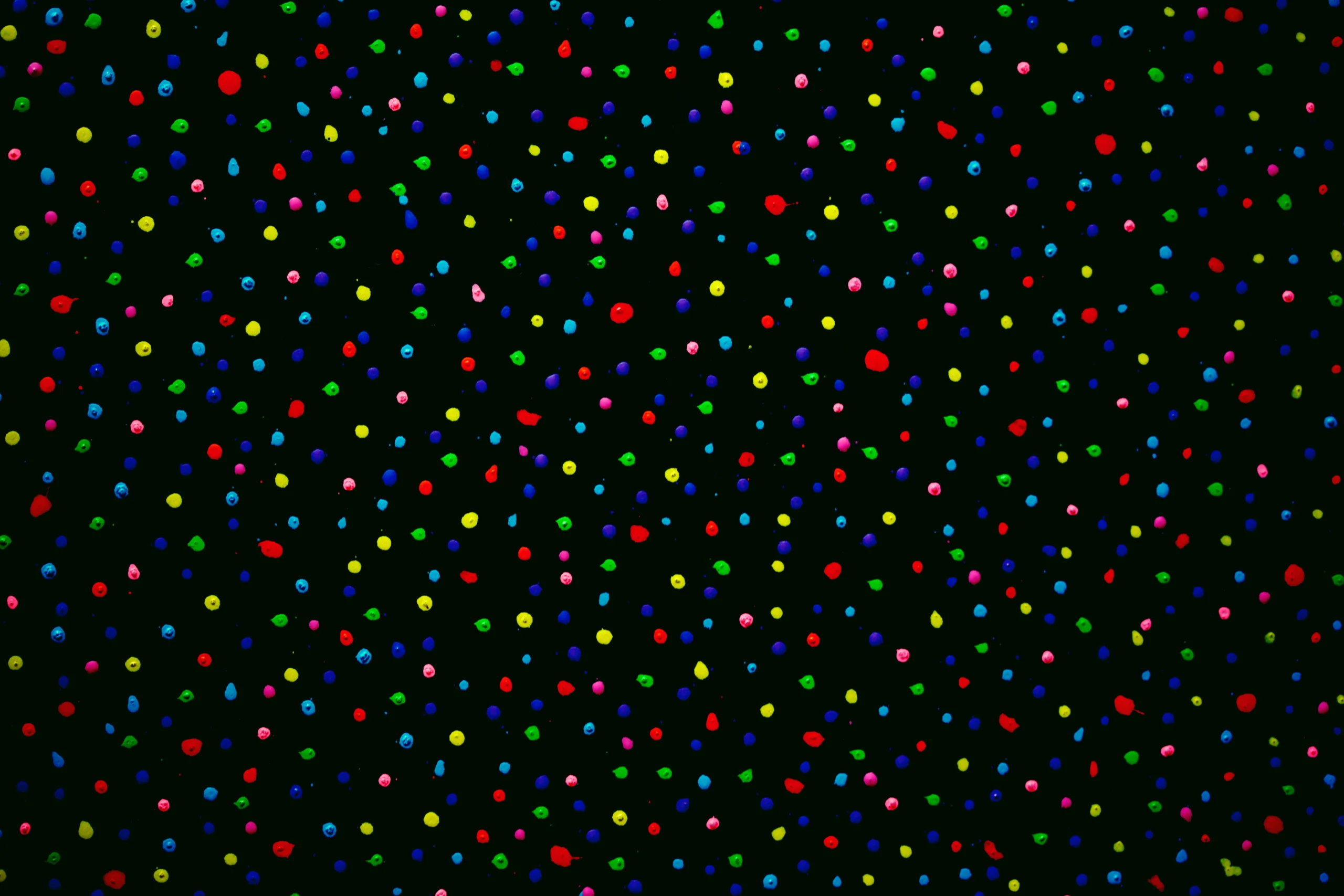 Vibrant abstract art with colorful dots scattered across a black background